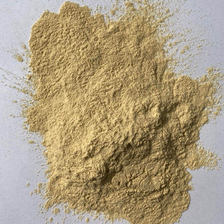 Close-up of a pile of light brown powder on a gray background