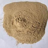 Clump of brown sand or soil on a light gray background