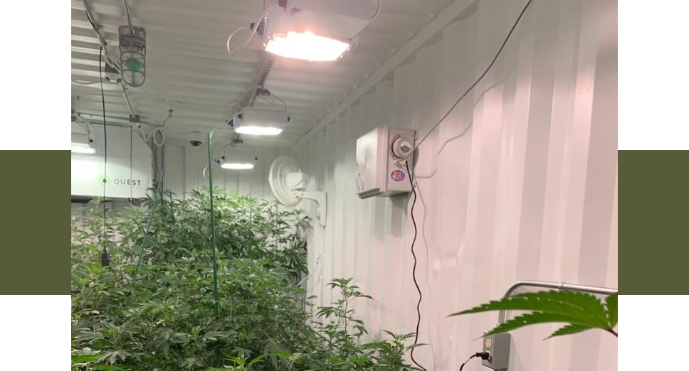 Side view of AirROS 40XX installed in a grow room with lights on ceiling above and fan on the wall behind
